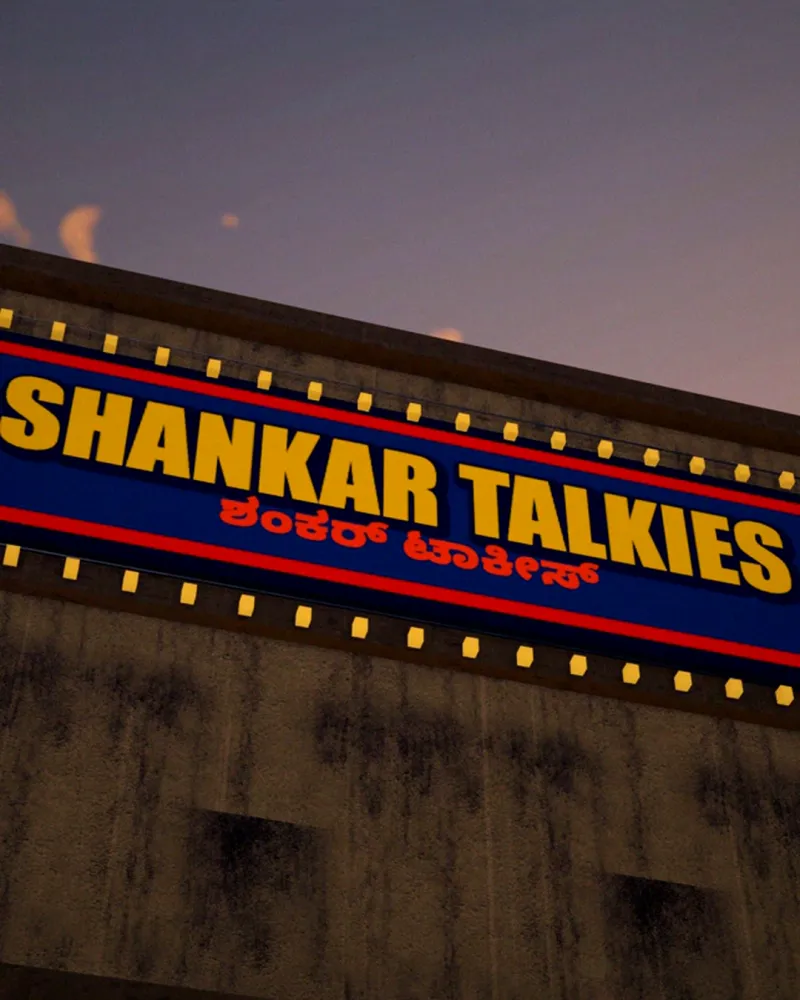 The lit sign of an old single-screen cinema against a dusk sky.